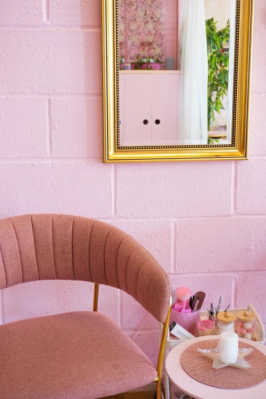 Blush velvet seating beside a gold-framed mirror