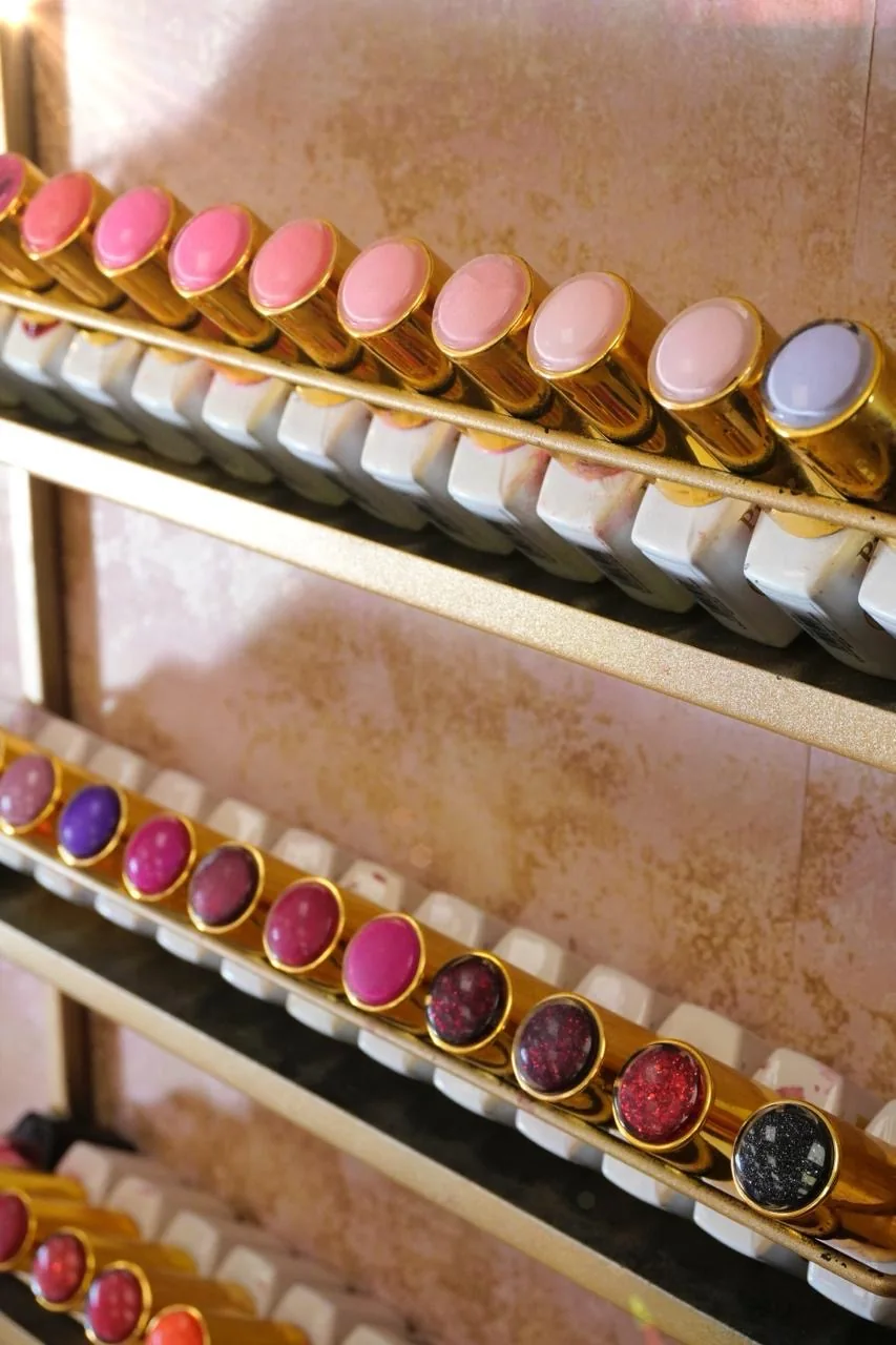 A spectrum of pink nail shades in gold-topped bottles