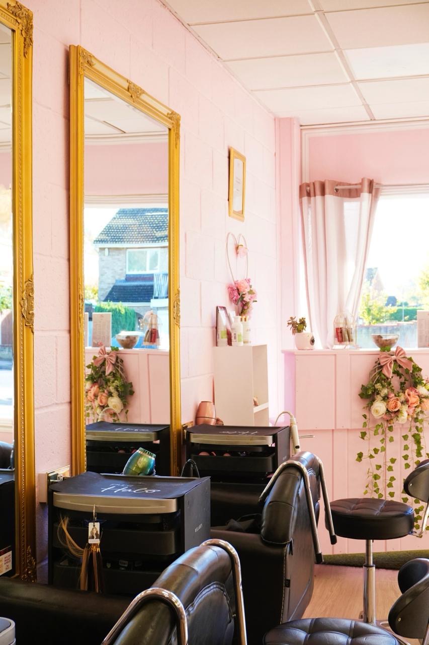 Gold mirrors and styling chairs in Naturally U’s pink hair salon
